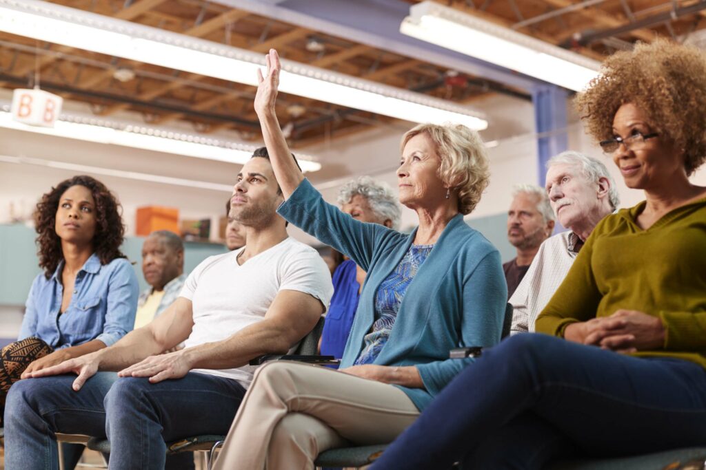 Woman Asking Question At Neighborhood Meeting In Community Center